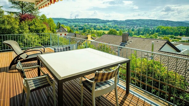A balcony with a table and chairs, overlooking a scenic landscape with houses and trees. - Apartment mit Terrasse nahe Schweizer Grenze by Interhome (Weil am Rhein)