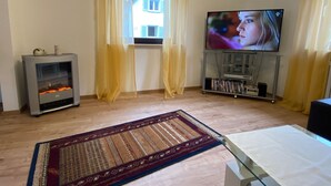 A living room with a fireplace, a television, and a bookshelf. - Mayer in Oberkirch by Interhome (Oberkirch)