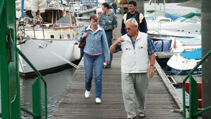 Een houten steiger met boten in een jachthaven.