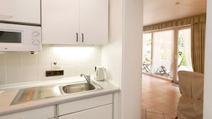 A modern kitchen with white cabinets, a built-in microwave, and a sink. - in Walkenried mit Schöner Terrasse by Interhome (Walkenried)