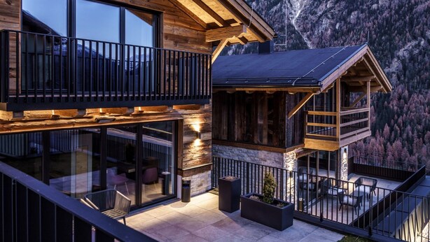 A wooden chalet with a balcony, large windows, and a view of mountains. - Mont Blanc by Interhome (Sölden)