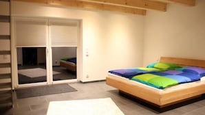 Makuuhuoneessa on puinen sänky, liukuovilla varustettu vaatekaappi ja laatoitettu lattia.