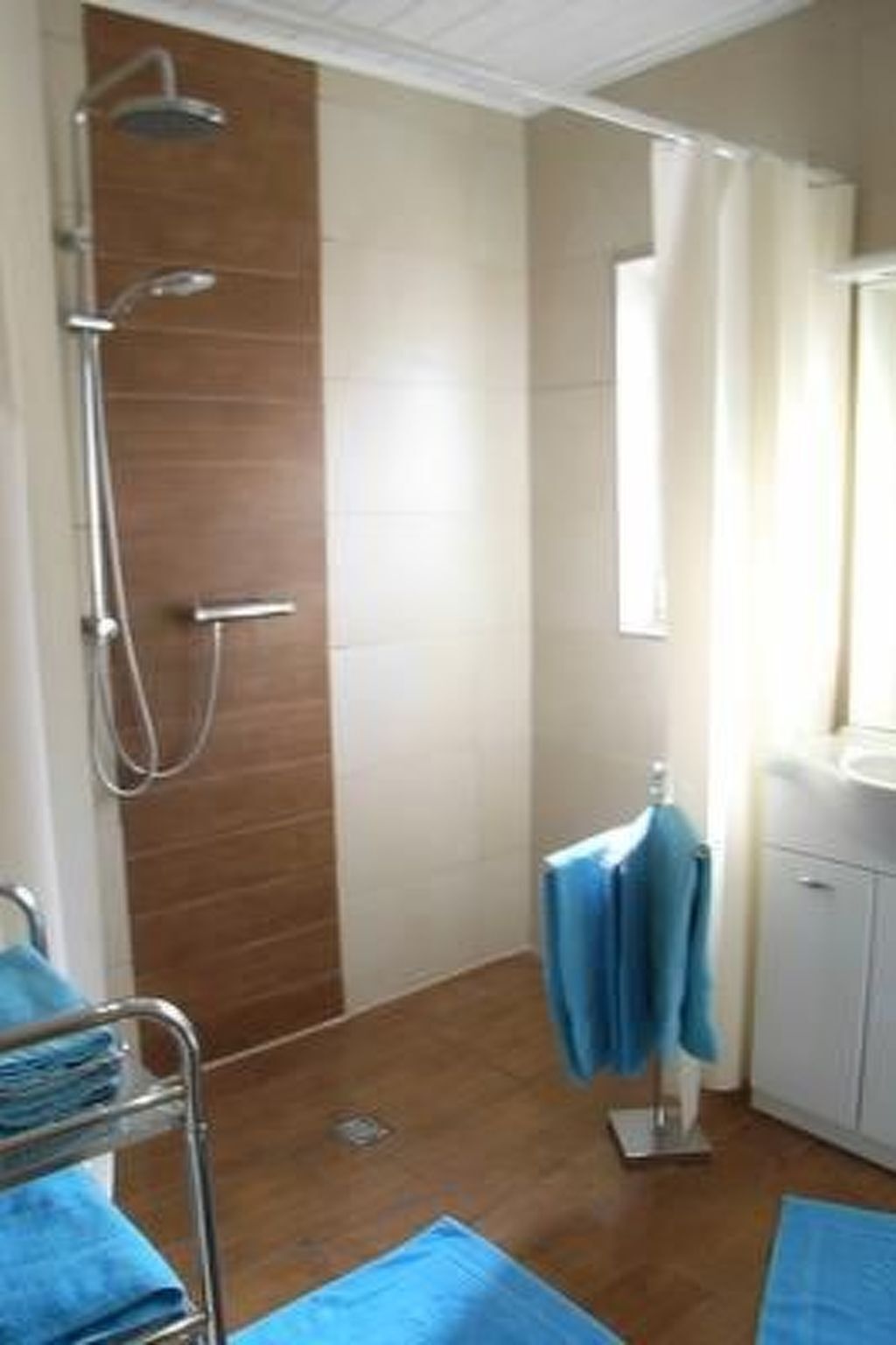 A bathroom with a shower, a sink, and a mirror.