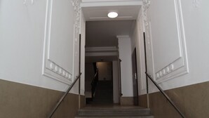 A staircase with a handrail, leading to a landing with a door. - Wohnen am Augarten by Interhome (Vienna)