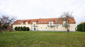 A two-story building with a red-tiled roof, a flat facade, and a small front garden. - Urlaubszuhause by Interhome (Naundorf)
