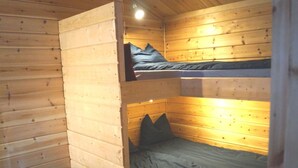 A cabin with a wooden interior, featuring a bunk bed with a mattress and pillows, and a lower bunk with a mattress and pillows. - Järvstuga by Interhome (Arvidsjaur)