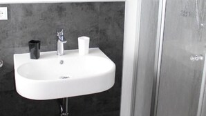 A bathroom with a white sink, a mirror, and a shower enclosure. - FEWO-Pfenniggeiger by Interhome (Philippsreut)