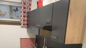 Une cuisine moderne avec un fourneau noir, un évier et un réfrigérateur.