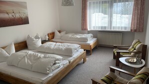 A room with two single beds, a wooden chair, a small table, a radiator, and a window with sheer curtains. - FEWO-Pfenniggeiger by Interhome (Philippsreut)