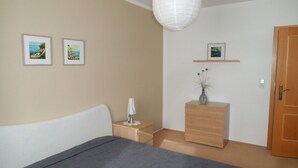 A bedroom with a bed, bedside table, dresser, and a door. There are two framed pictures on the wall. - Sassnitz In by Interhome (Sassnitz)