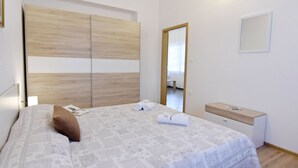 A bedroom with a bed, a bedside table, a mirror, and a wardrobe. - Zweizimmerwohnung mit großer Terrasse in Grupija by Interhome (Umag/Savudrija)
