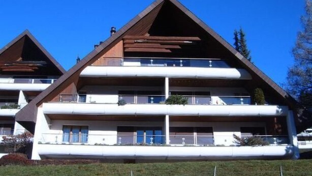 A modern multi-story building with a sloped roof, balconies, and a flat facade. - Churfirsten by Interhome (Unterwasser)