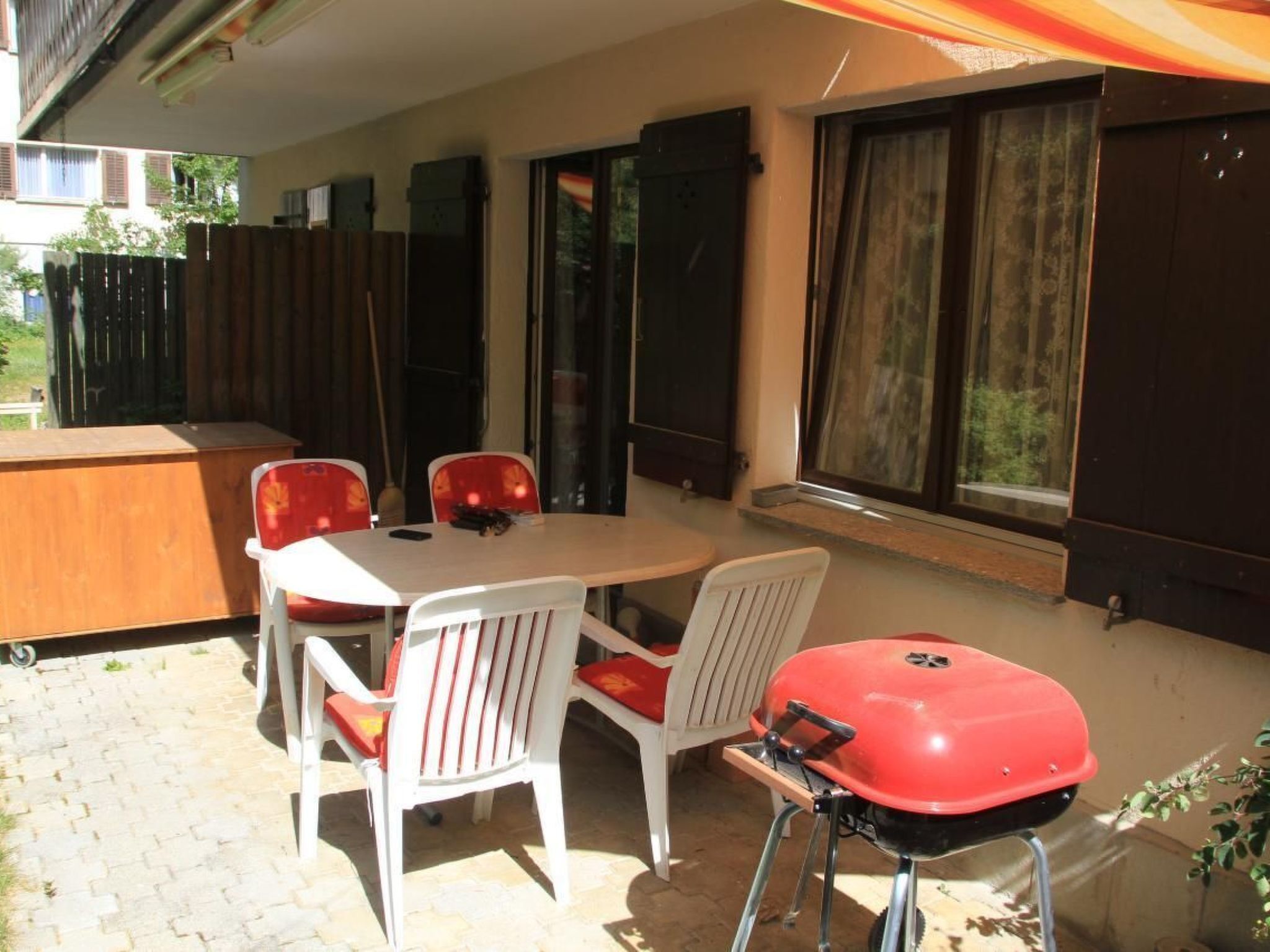 Eine Außenpatio mit Tisch und Stühlen, einem Grill und Blick auf die Umgebung.
