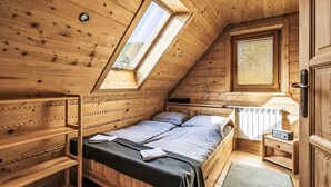 Uma cabana de madeira com quarto no mezanino, janela, radiador e porta.
