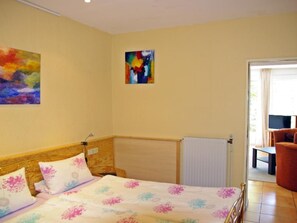 A bedroom with a bed, a radiator, a painting on the wall, and a view of the outside. - Göttert by Interhome (Dickenschied)