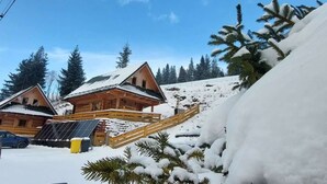 A wooden cabin with a sloped roof, a wooden deck, and a solar panel. - Chata Martina A by Interhome (Zdiar)