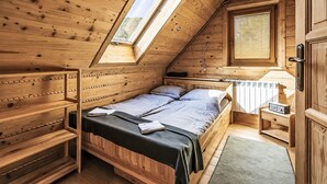A wooden cabin with a loft bedroom, a built-in bench, a window, and a radiator. - Chata Martina A by Interhome (Zdiar)