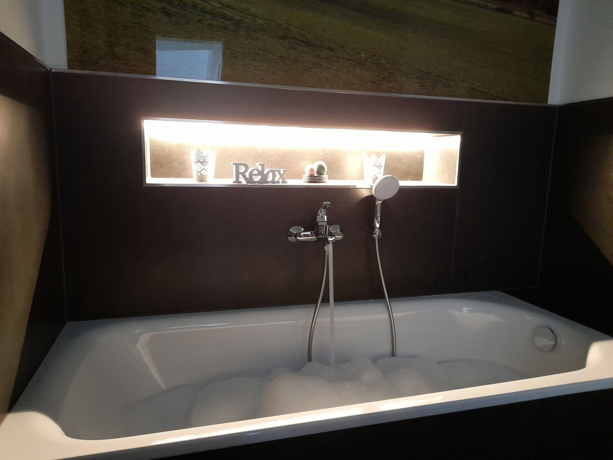A modern bathroom with a bathtub, a shower, and a vanity with a mirror.