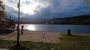 Une promenade au bord du lac, avec un banc, un lampadaire et un petit quai pour bateaux.