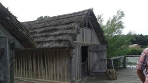 A rustic wooden building with a thatched roof, situated on a wooden deck. - Apartment Ole by Interhome (Oldenburg in Holstein)