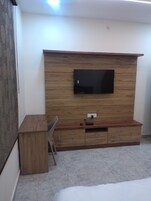 Un dormitorio con una estantería de madera, una cama y un escritorio.