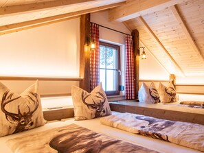 A cozy cabin room with wooden beams, a window with curtains, and animal-themed pillows. - in Gemeinde Hermagor-Pressegger See mit Terrasse, Grill und Garten by Interhome (Tröpolach)