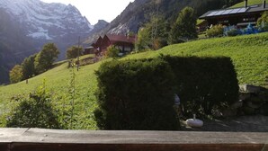A mountain cabin with a red roof, surrounded by lush greenery and snow-capped peaks in the background. - Husmättli by Interhome (Lauterbrunnen)