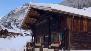 A wooden chalet with a sloped roof, surrounded by snow-covered mountains. - Husmättli by Interhome (Lauterbrunnen)