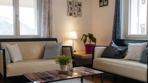 Ein gemütliches Wohnzimmer mit zwei Sofas, einem Couchtisch und einer Lampe.
