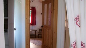 A hallway with a wooden door leading to a room with a red curtain. - in Sankt Koloman mit Bergblick by Interhome (St. Koloman)