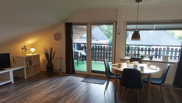 A cozy room with a dining table, chairs, a TV on a stand, and a bookshelf. - Amselnest by Interhome (Wiesmoor)