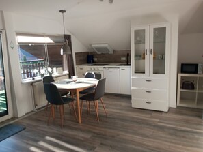 Een koelkast, een microgolfoven, een oven, kookgerei, borden en bestek