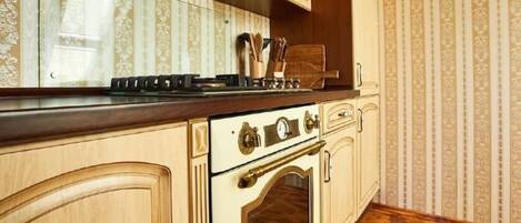 Cocina con encimera de madera, estufa y armarios.