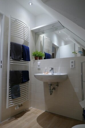 A modern bathroom with a built-in towel rack, a sink, and a mirror.