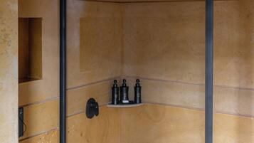 A modern bathroom with a wooden wall design, a black door, and a shelf with toiletries.