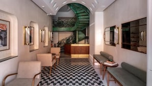 A modern interior with a staircase, seating areas, and framed artwork. - Abode Jaipur (Jaipur)
