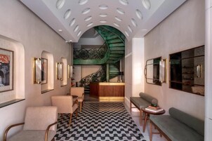 A modern interior with a staircase, seating areas, and framed artwork.
