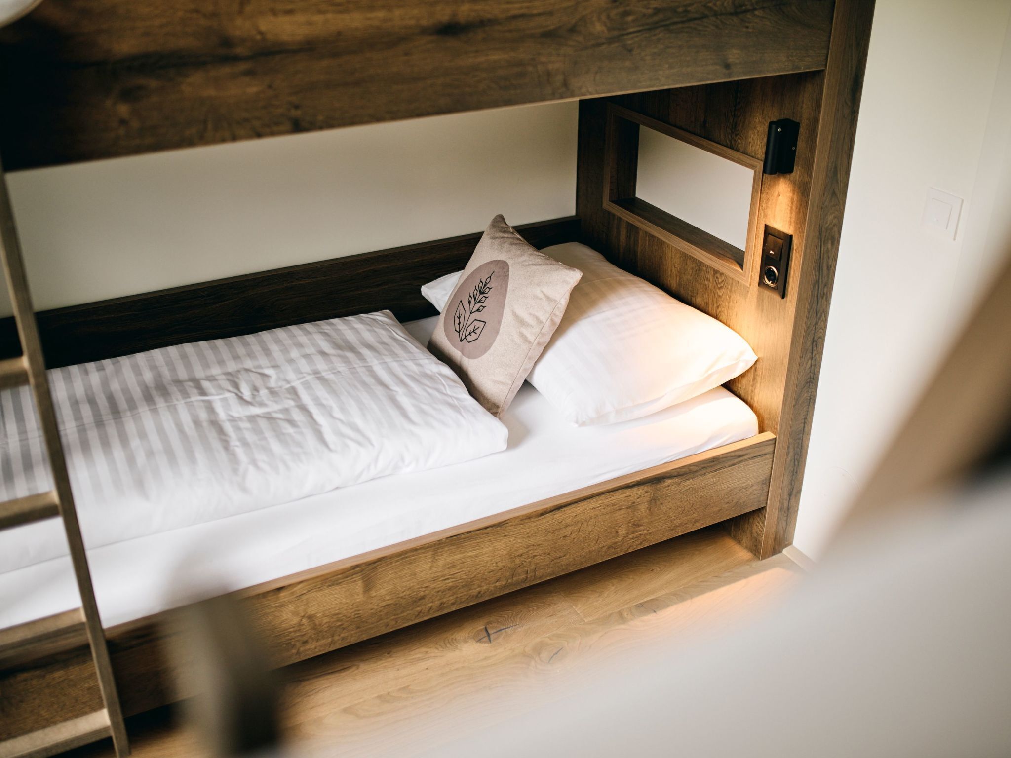 A bunk bed with a wooden headboard and a single bed below.