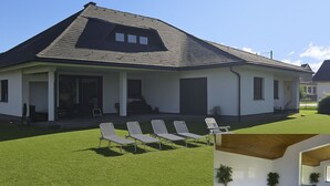 Et moderne hus med en overdækket terrasse, swimmingpool og en velplejet græsplæne.