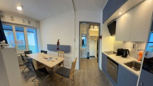 Una cocina moderna con comedor, que incluye una mesa, sillas y un horno empotrado.