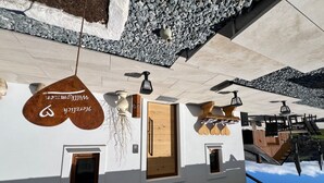 A building with a white facade, a wooden door, and a sign with Arabic script. - Sonnenschein1 by Interhome (Eibiswald)