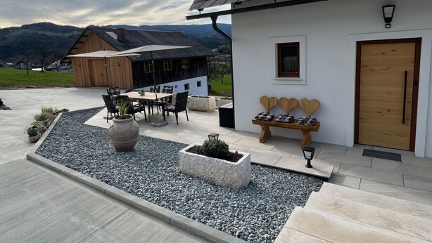 A modern house with a tiled patio, outdoor seating, and a view of the surrounding landscape. - Sonnenschein1 by Interhome (Eibiswald)