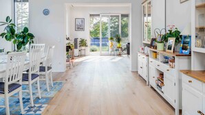 A bright, spacious kitchen with a dining area, large windows, and a view of the outdoors.