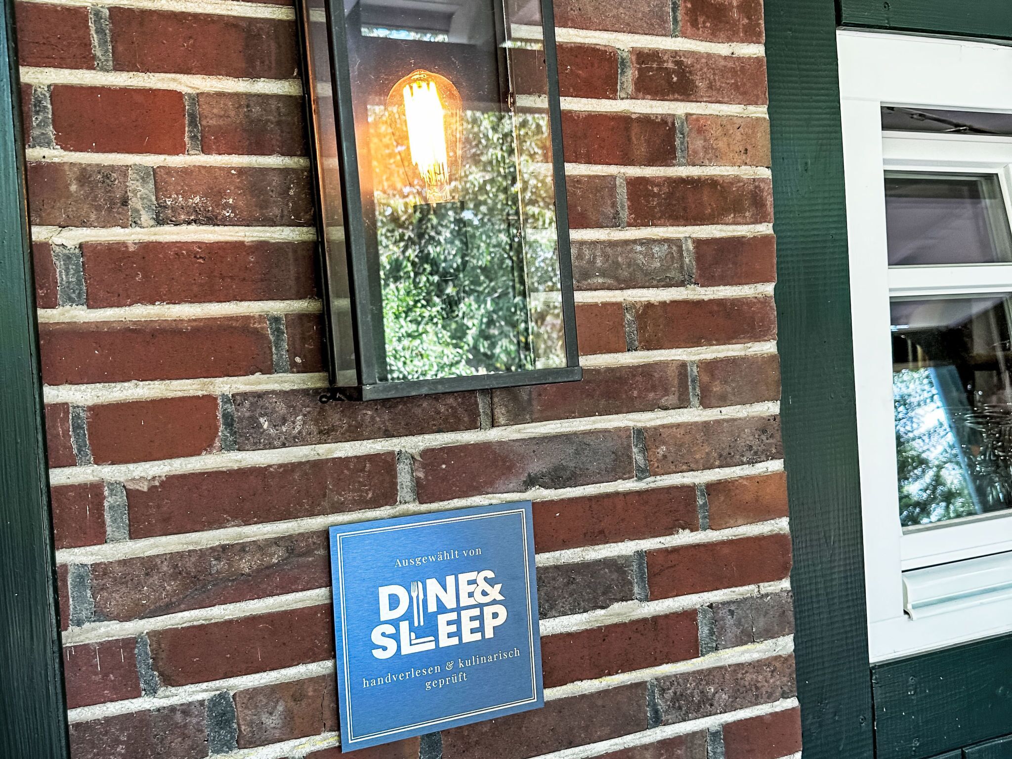 A brick wall with a sign for 'DINE & SLEEP' indicating handwoven and culinary craftsmanship.