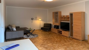 Een moderne woonkamer met een bank, een salontafel, een tv-meubel en een kast.