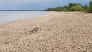 Una spiaggia sabbiosa con mare calmo e cielo nuvoloso.