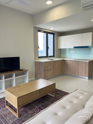 Ein modernes Wohnzimmer mit einem Flachbildfernseher, einem Holztisch und einem weißen Sofa.