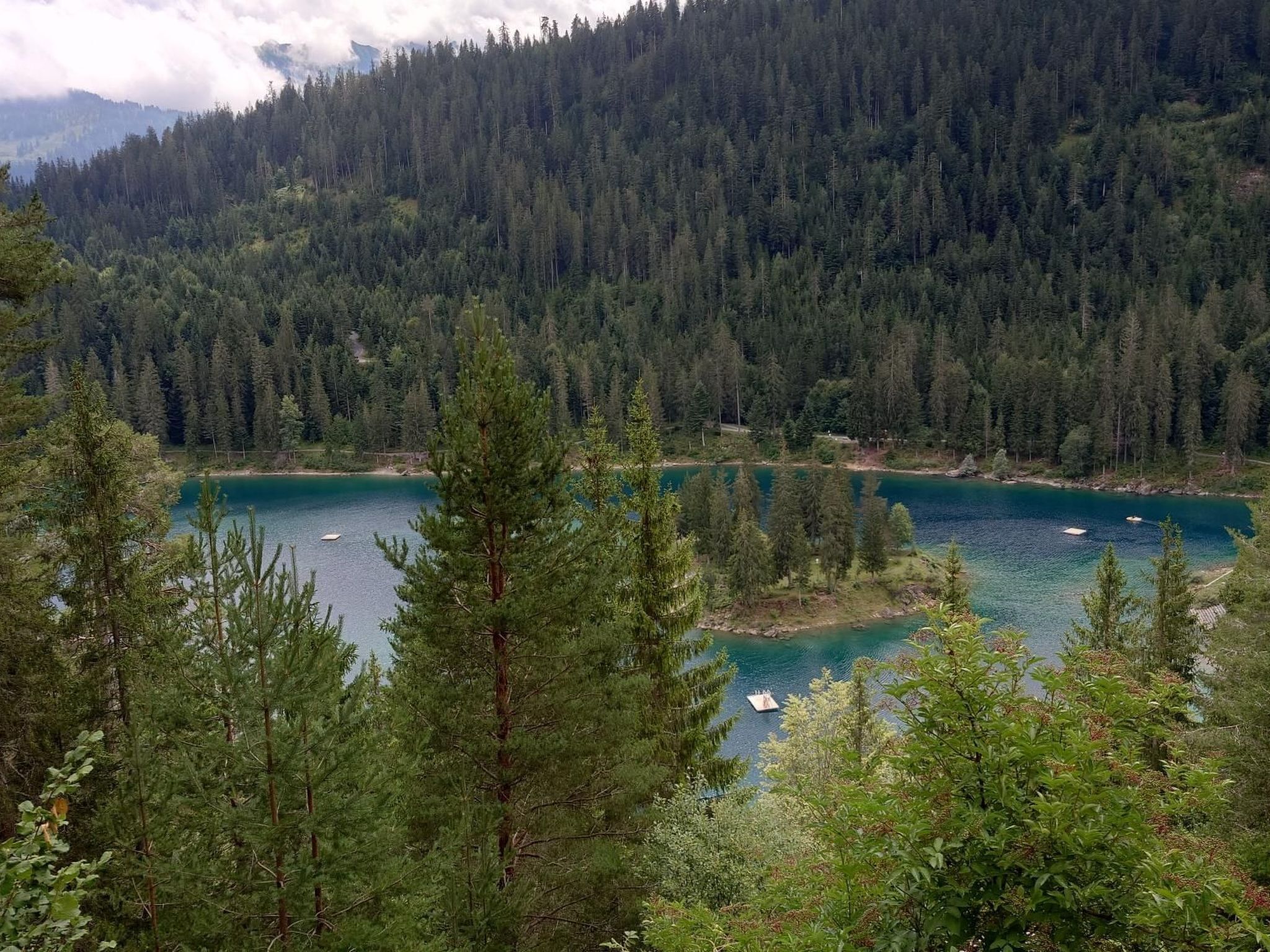 Un lac entouré d’une forêt dense et de montagnes.
