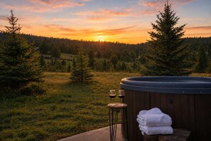A hot tub with a wooden deck, two glasses of red wine, and a stack of towels. - The Drift at Firelight | Big Sky Adventure+Hot Tub (Big Sky)
