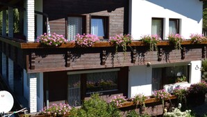 A two-story building with wooden balconies, windows with curtains, and flower boxes. - Haus Tauber by Interhome (Jerzens)